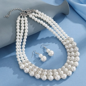 Macro detail of multi-layer pearl necklace with rhinestone spacers and matching earrings
