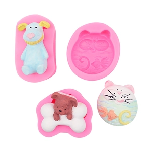 Detail of pink silicone mold with finished cartoon dog and cat shaped fondant pieces