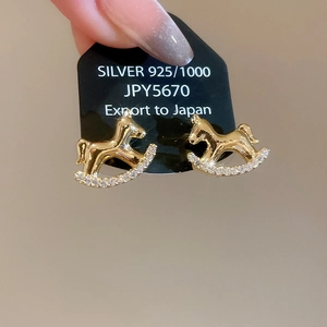 Détail des boucles d'oreilles cheval à bascule en argent S925 doré avec pavage de zircons