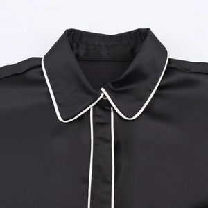 Lustrous black satin shirt with contrasting white piping detail and button-down collar