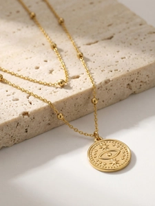 Détail du collier double rang avec pendentif œil maléfique doré sur pierre