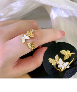 Macro detail of gold butterfly ring with white enamel and sparkling cubic zirconia stones