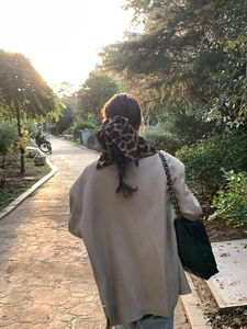 Leopard print fabric scrunchie tied on a braided ponytail with soft sunset lighting