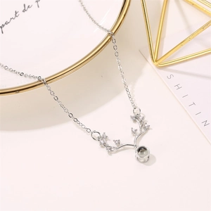 Silver reindeer antler necklace with zircon and projection stone on a white tray