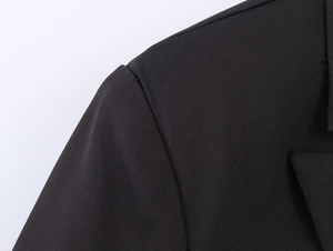 Close-up of the shoulder detail on a tailored double-breasted black blazer for women