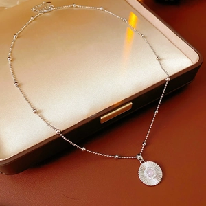 Vue détaillée du collier à billes argenté avec pendentif marguerite en zircone rose
