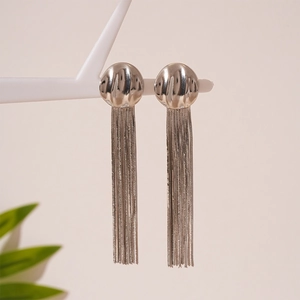 Detail of elegant silver tassel drop earrings hanging on a white decorative stand
