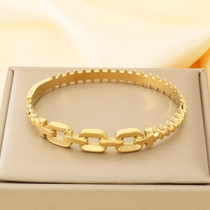 Detailed macro shot of gold-plated chain link bangle with polished textured finish