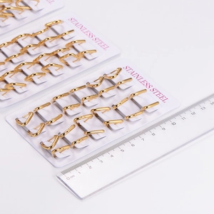 Golden stainless steel geometric ear buckles arranged neatly on professional white cards