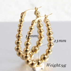Close-up of 23mm gold stainless steel U-shaped beaded hoop earrings with size details