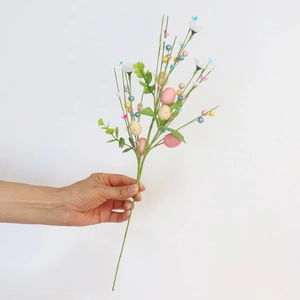 Easter floral branch with colorful speckled eggs, white flowers and faux berries for home decor