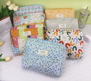 Variety of quilted cotton cosmetic bags in floral and plaid patterns for storage