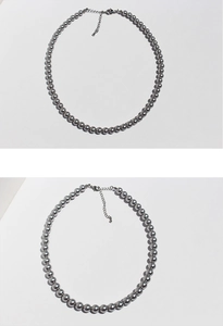 Close-up of silver-grey pearl necklace showing lobster clasp and extension chain