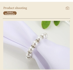 Macro shot of faux pearl napkin ring with silver rhinestone accents on a white napkin