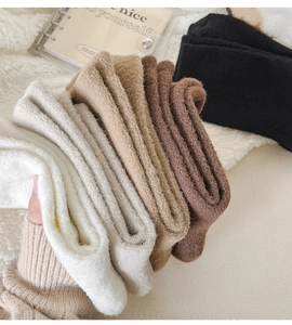Macro shot of thick winter thermal socks in five earth tones on a soft plush blanket