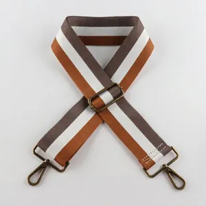 Macro shot of adjustable 5cm wide striped bag strap with vintage bronze metal hooks