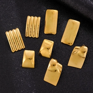 Macro shot of assorted geometric gold stainless steel earrings on a black glitter background