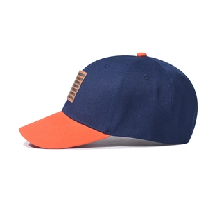 Two-tone baseball cap in navy blue and orange with rectangle patch on white background