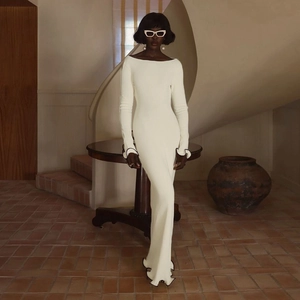 Detalle del vestido de punto blanco con bordes ondulados negros y dobladillo plisado
