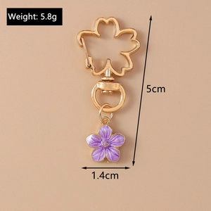 Detail shot of purple floral keychain with gold hook and 5.8g weight dimensions