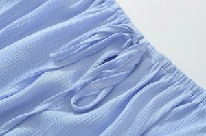 Vue détaillée de la taille élastique bleu clair avec nœud papillon et tissu plissé fluide
