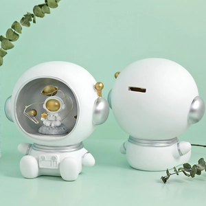Cute resin astronaut piggy bank set with golden space details on green background