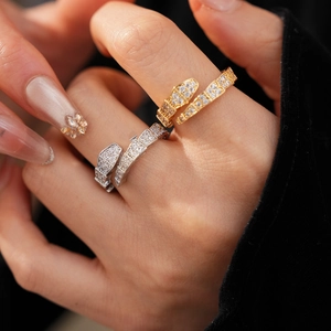 Detail of snake head ring with sparkling cubic zirconia on hand in gold and silver