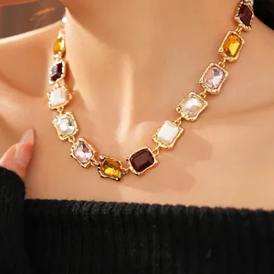 Vintage gold necklace with colorful rectangular gemstone inlay worn on a model's neck