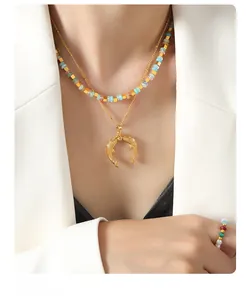 Détail du collier pendentif queue de poisson dorée et bijoux perlés multicolores