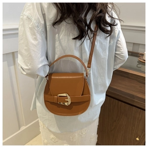 Detail of a brown PU leather crossbody bag featuring metal buckle and adjustable strap