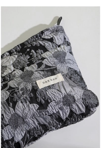 Vue macro du tissu jacquard français et de l'étiquette tissée H&R BAG sur la trousse
