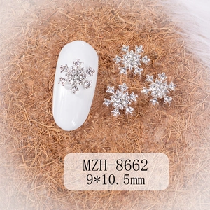Macro shot of silver snowflake nail art charms with crystals for winter DIY manicure