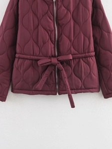 Detail of burgundy quilted jacket showing waist tie and gourd pattern stitching