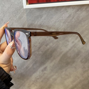 Detail of transparent brown square frame glasses with anti-blue light lenses and metal hinges