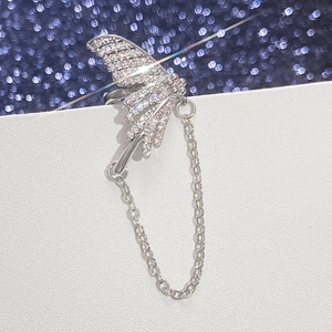 Detailed view of silver wing ear cuff with sparkling zircons and long chain tassel