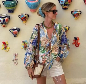 Detail of colorful graffiti print cardigan blouse with tied waist and V-neckline