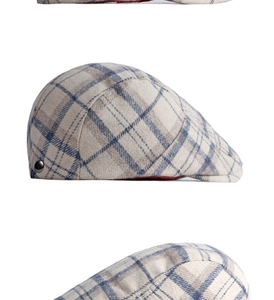 Close-up of wool plaid ivy cap with classic beige pattern, metal button and red lining