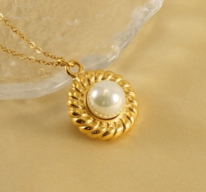 Detailed view of an 18k gold-plated twisted pendant with a lustrous round white pearl
