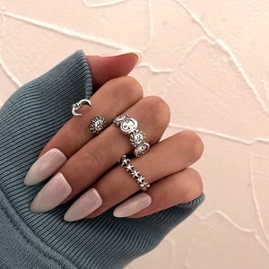 Detail of silver gothic rings with sun, moon, and star motifs on a model's hand