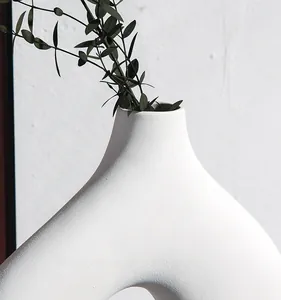 Detailopname van de matwitte keramische vaas met elegante textuur en artistiek gebogen design