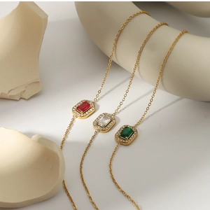 Detailed close-up of 18K gold-plated bracelets featuring square zircon gemstone charms