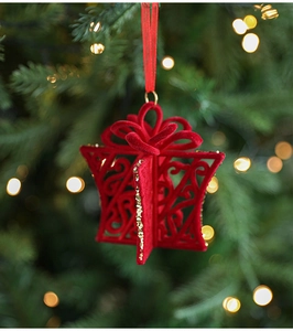 Detail of red flocked Christmas gift box ornament with gold glitter on tree branch