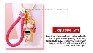 Close-up of golden whistle keychain with pink and white rhinestones and braided strap