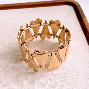 Detailed macro view of vintage gold heart-shaped metal plates with elastic cord