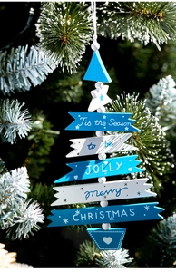 Detail of wooden Christmas tree ornament with blue and white colors on snowy pine branch