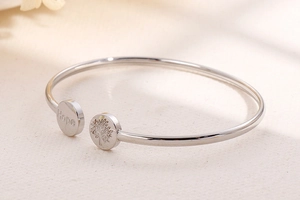 Macro detail of silver bangle featuring Hope engraving and Tree of Life symbol