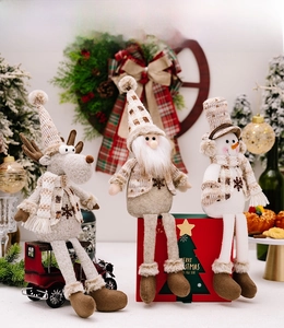 Detailansicht von drei hängenden Weihnachts-Plüschfiguren mit langen Beinen auf Boxen
