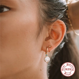 Close-up of S925 sterling silver gold hoop earrings with pearl and star stud