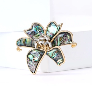 Elegant lily flower brooch with iridescent shell petals and crystals on golden metal