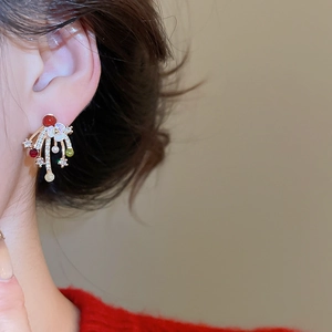 Close-up of gold-plated firework earrings with multicolored stones worn by model